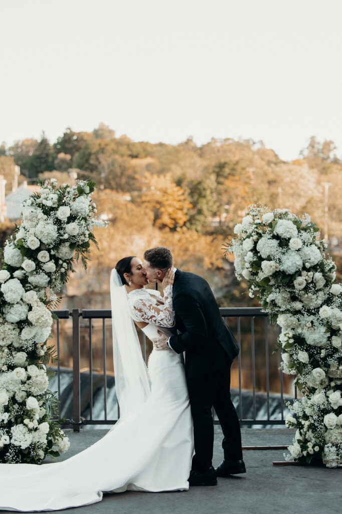 Bride and groom first kiss at new york wedding venue diamond mills