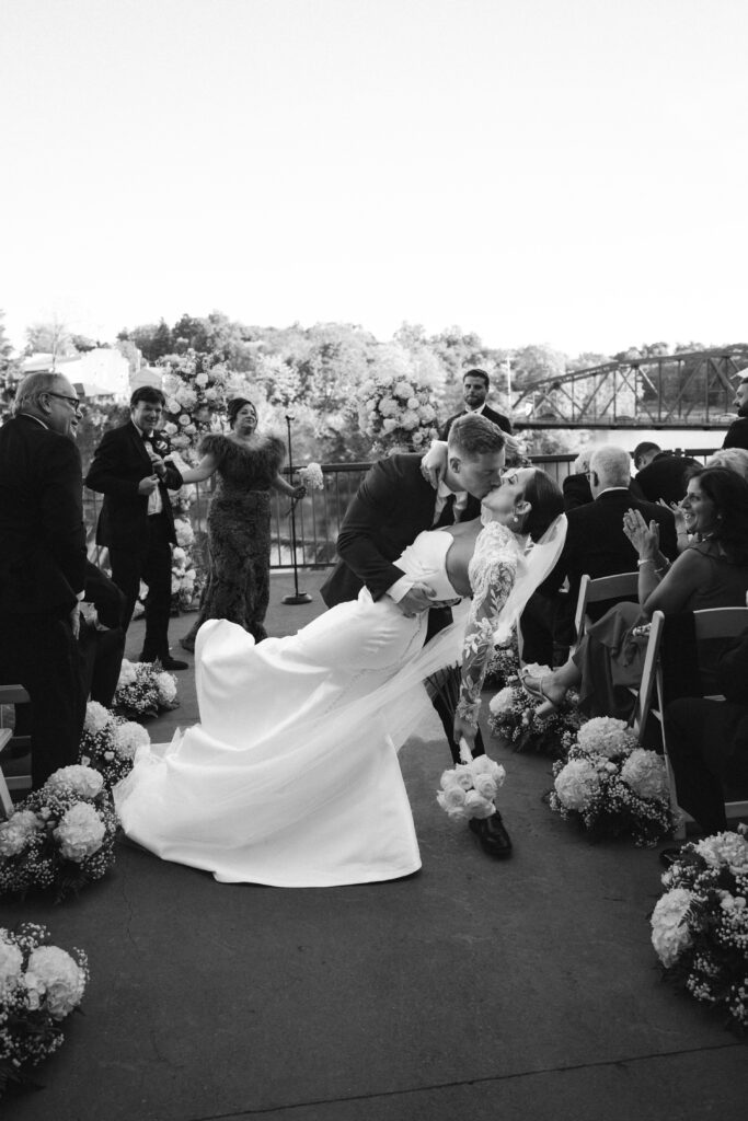 Bride and groom kiss down the aisle at new york wedding venue diamond mills