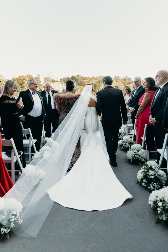 Bride walks down the aisle with parents at new york wedding venue diamond mills