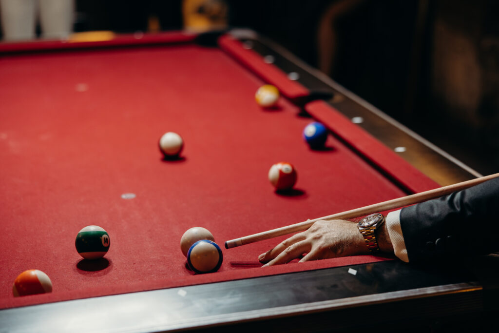 Groom and groomsmen playing billiards at The River Café NYC
