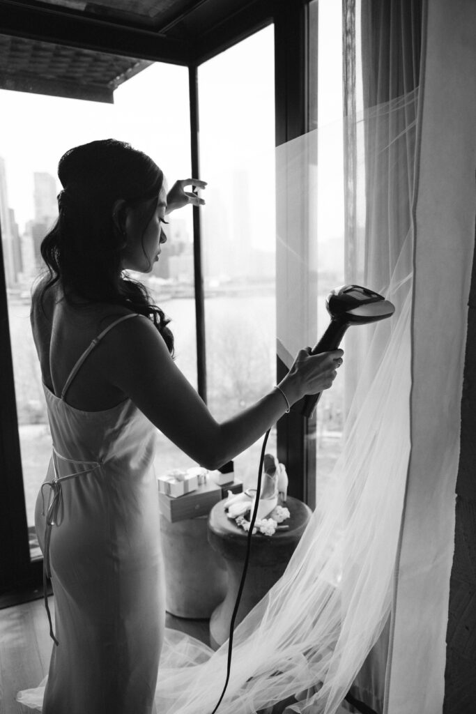 Bridesmaid irons the dress at The River Café NYC