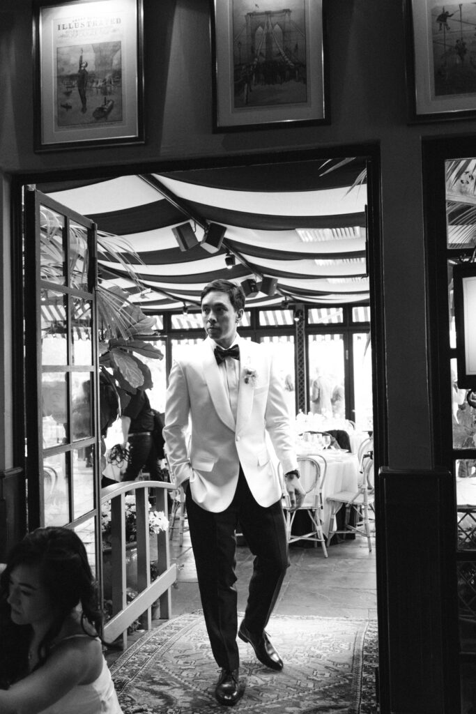 Candid shot of groom during cocktail hour at The River Café NYC