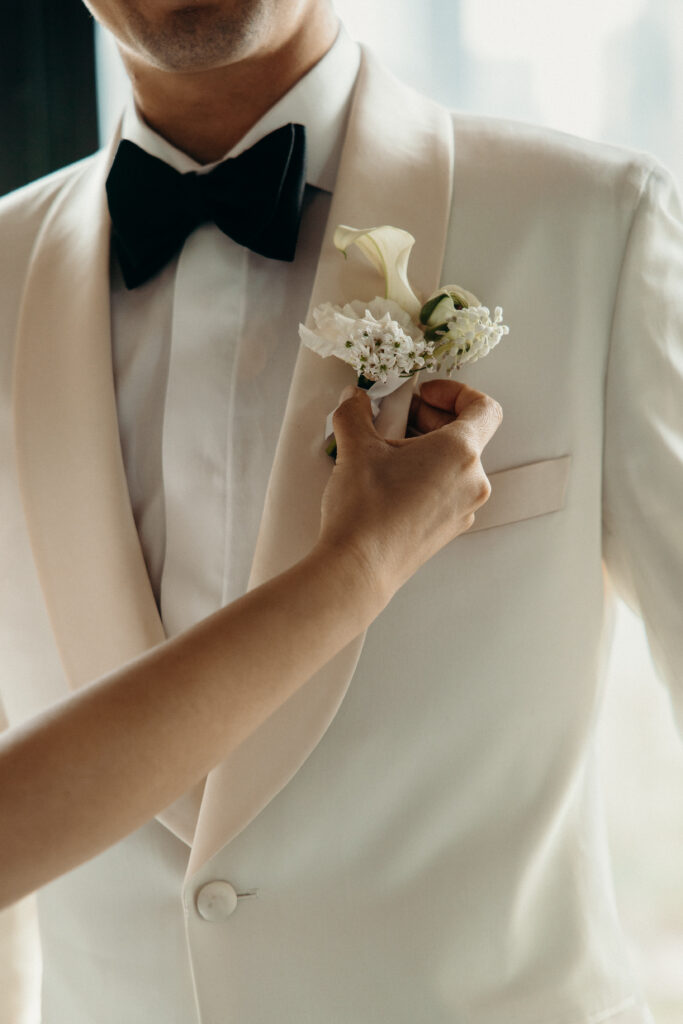 Bride fixes the groom’s boutonniere at The River Café NYC