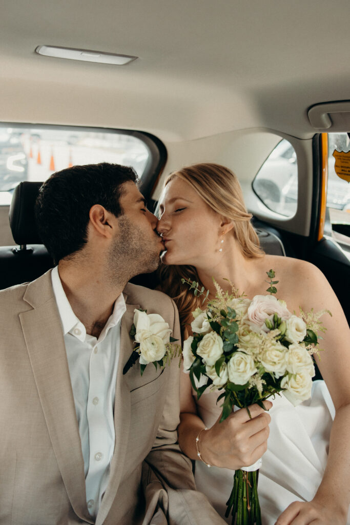 Couple shares a kiss in a taxi during their elopement