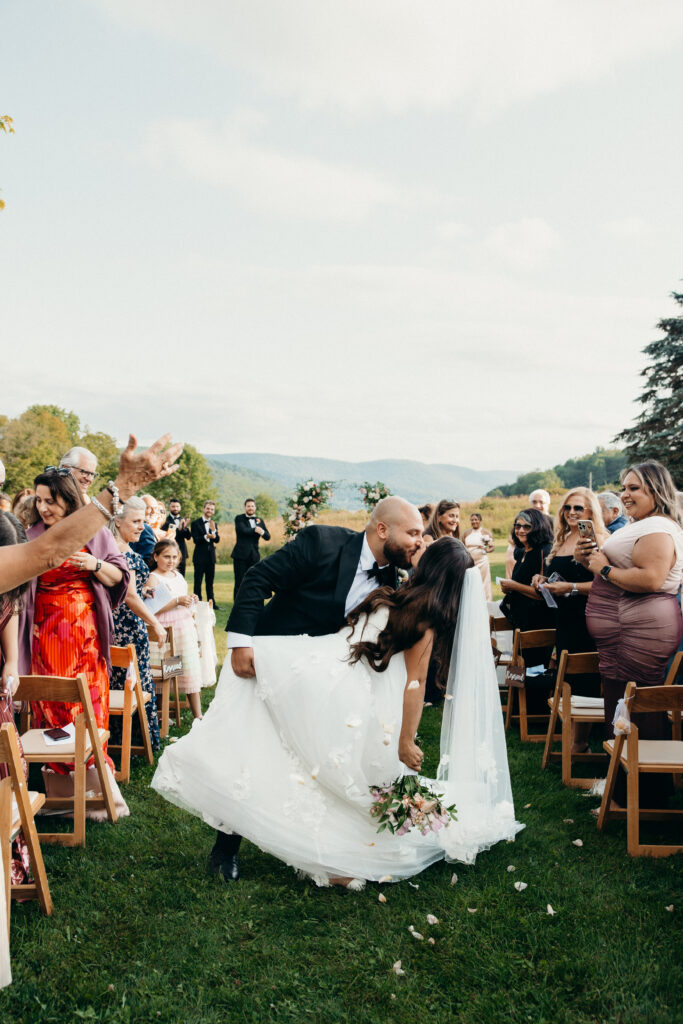 Bride and groom kiss down the aisle at Stonewall Estate