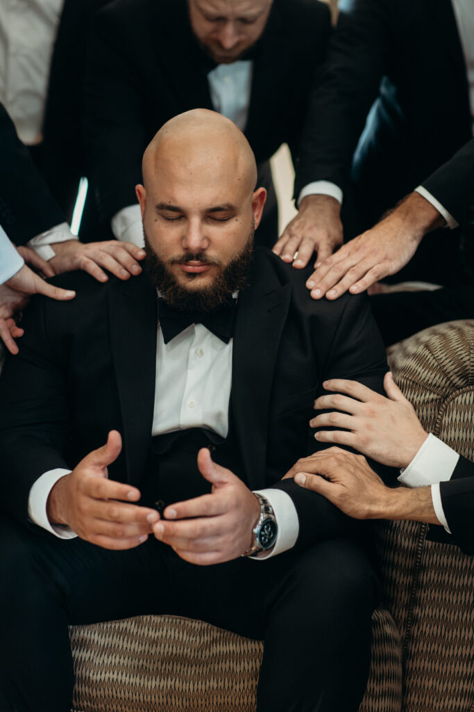 Groomsmen praying at Stonewall Estate