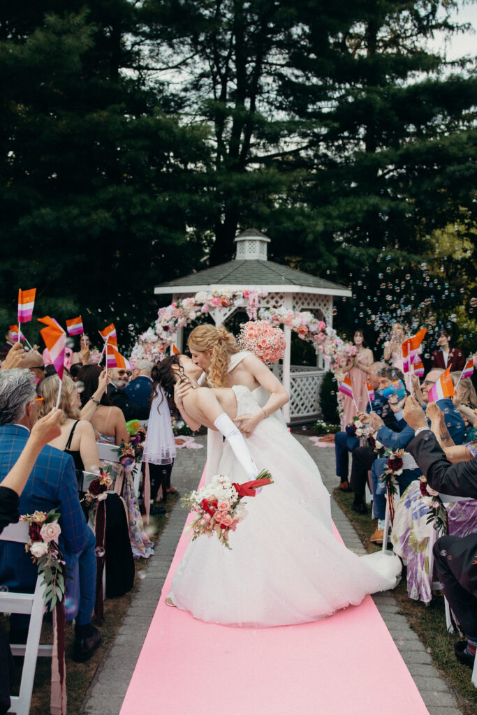 Brides share a kiss down the aisle at Mountainville Manor