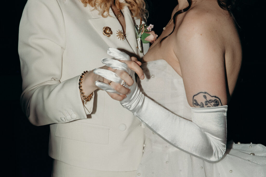 Brides hold hands during the evening reception at Mountainville Manor