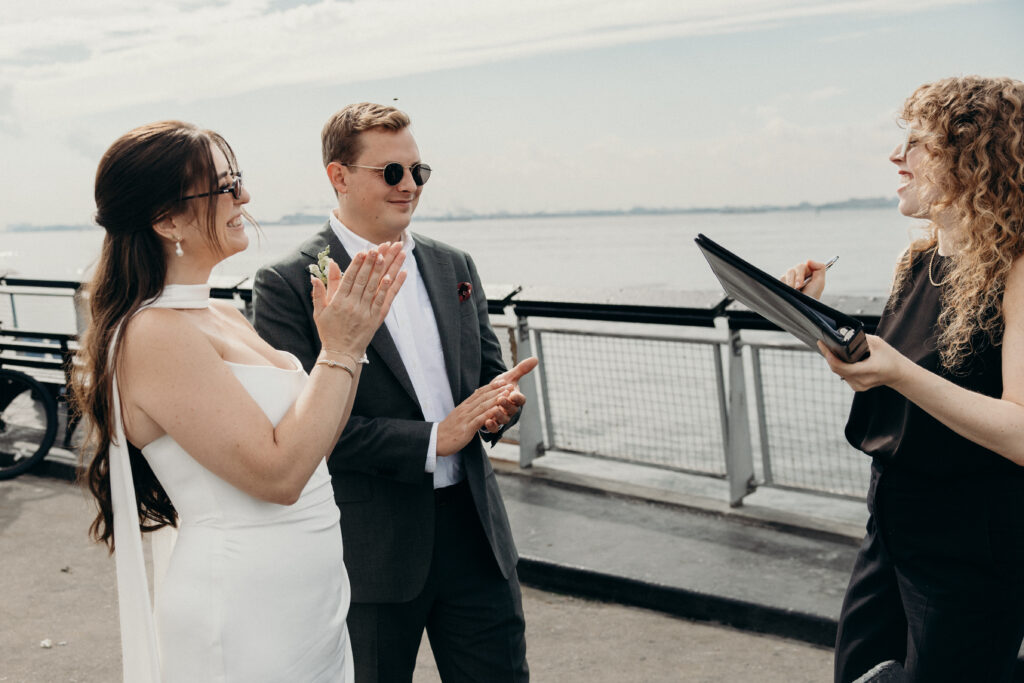 NYC couple clap their hands during their Red Hook elopement ceremony in Brooklyn