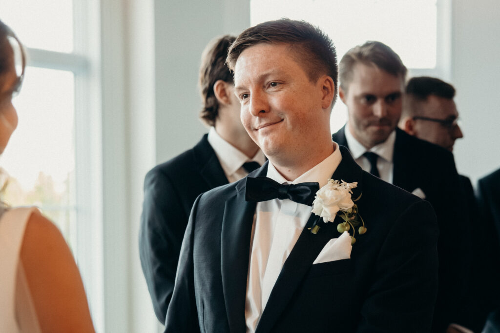 Groom smiles at the bride during their wedding ceremony at Maritime Parc