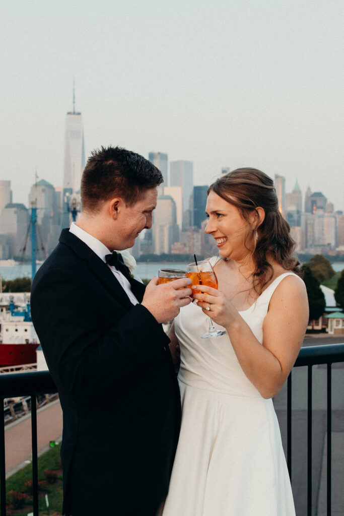 Couple cheers with their drinks during the wedding cocktail hour at Maritime Parc