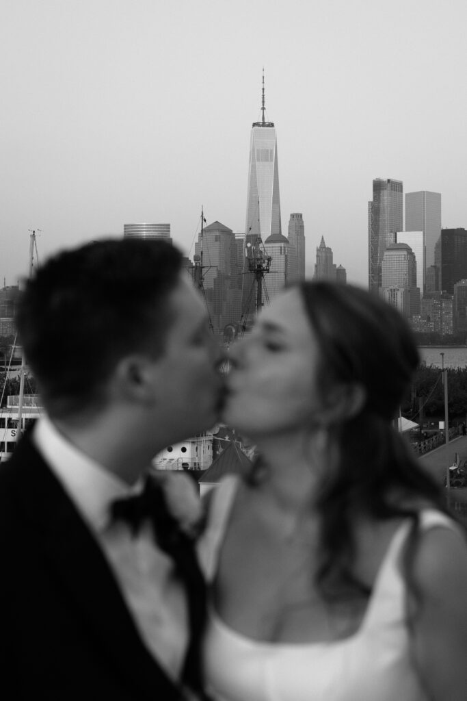 Couple share a kiss with a city backdrop at Maritime Parc