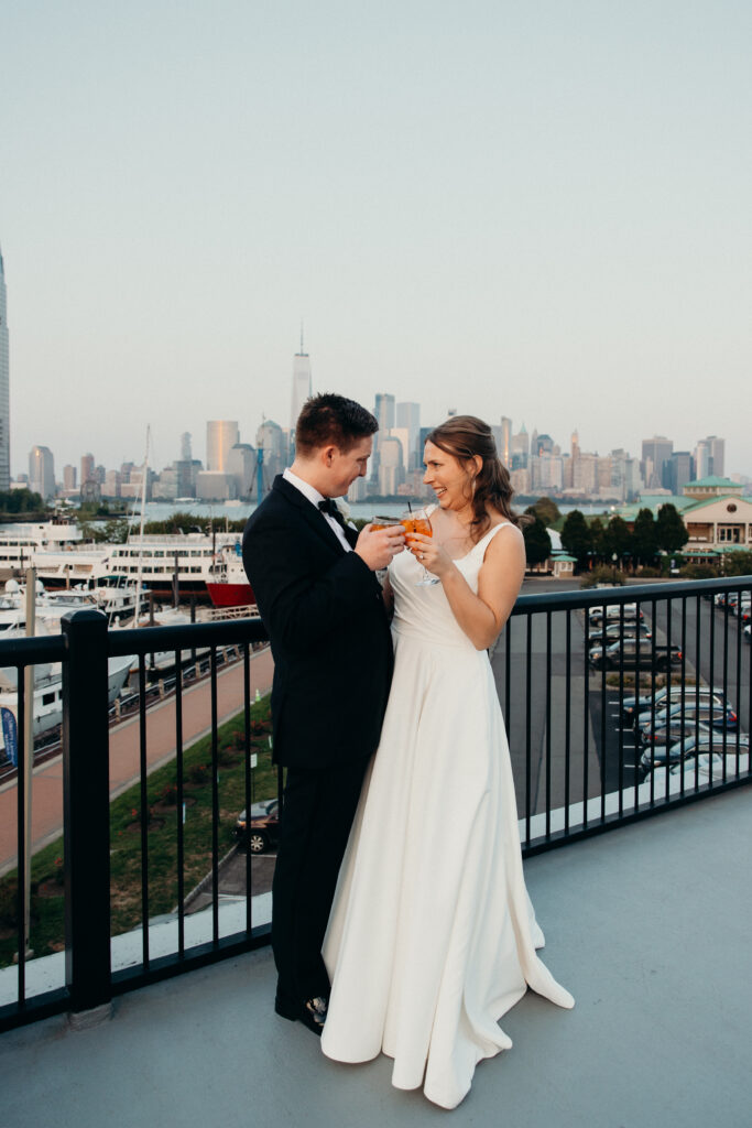 Couple cheers with their drinks during the wedding cocktail hour at Maritime Parc