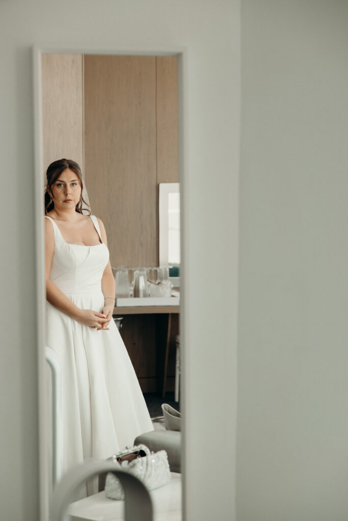 Bride looks in the mirror at a Maritime Parc wedding