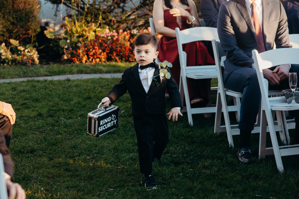 Ring bearer walking down the aisle at Sea Cliff Manor wedding ceremony