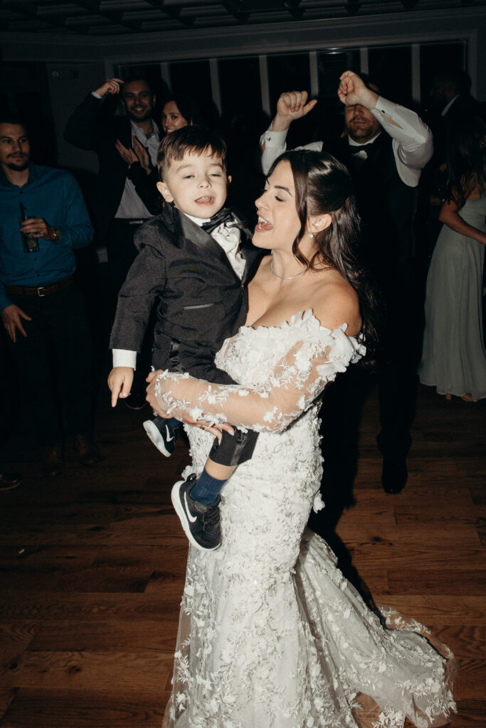 New York bride holding her son at Sea Cliff Manor wedding reception