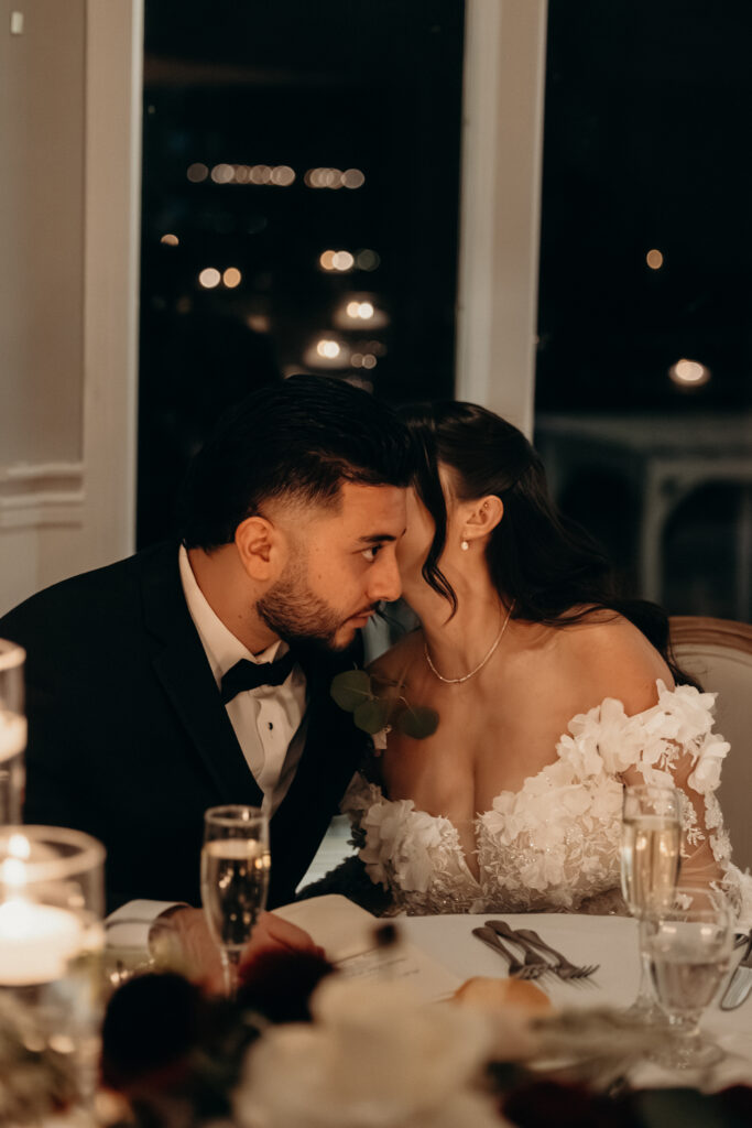 New York bride whispering to groom at Sea Cliff Manor wedding reception