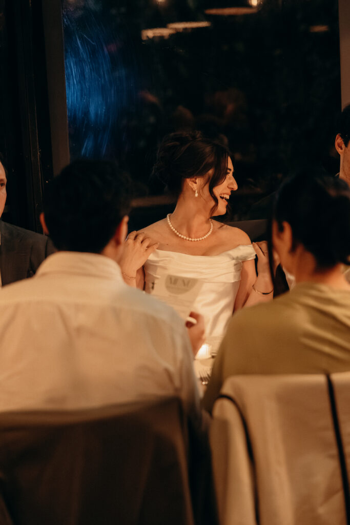 New York bride interacting with guests during dinner at her wedding celebration at Aurora Williamsburg
