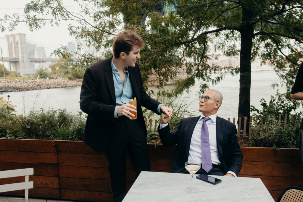 Groom and a wedding guest interacting at a Celestine DUMBO wedding reception 