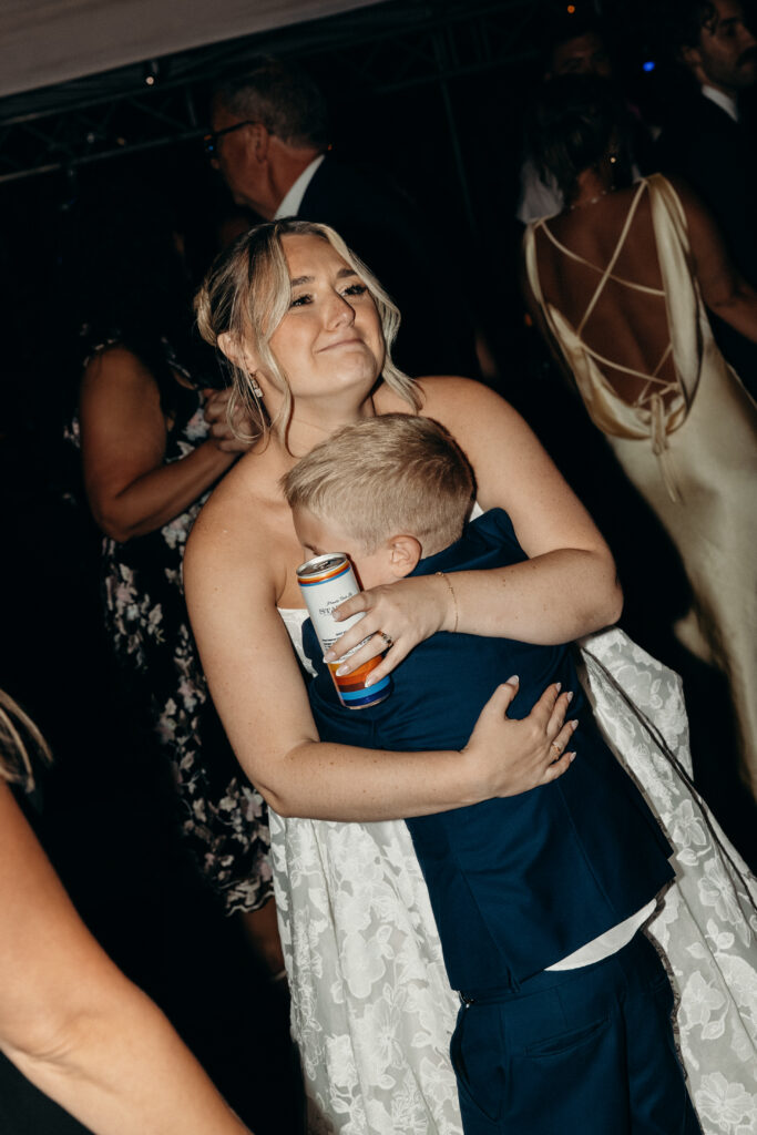 New York bride hugging kid at Arrow Park wedding reception