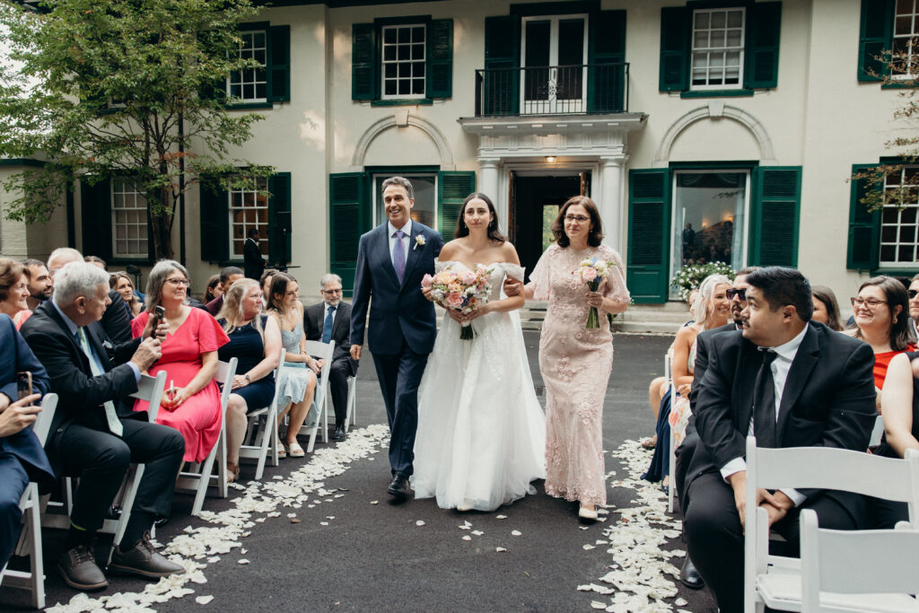 New York bride walking down the aisle with her parents at The Willows wedding ceremony