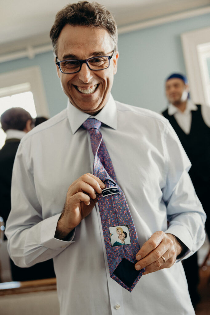Father of the groom showing off his tie while getting ready at The Willows in New York