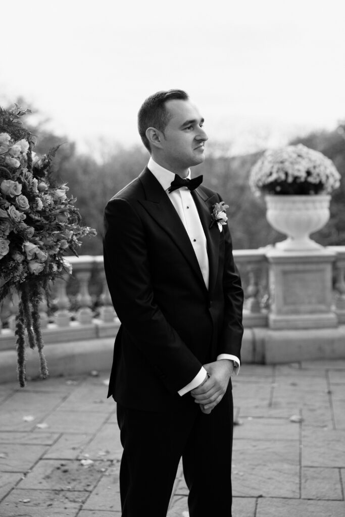 Groom watching the bride walk down the aisle during the wedding ceremony at Tarrytown House Estate