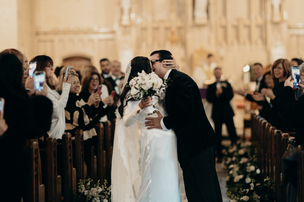 Couple kissing down the aisle at a New York church wedding