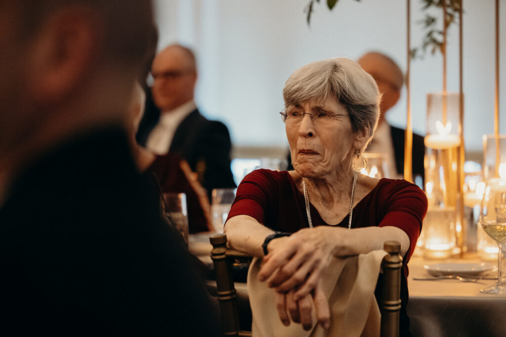 Grandmother watching couple dancing during first dance at Le Chateau New York wedding reception