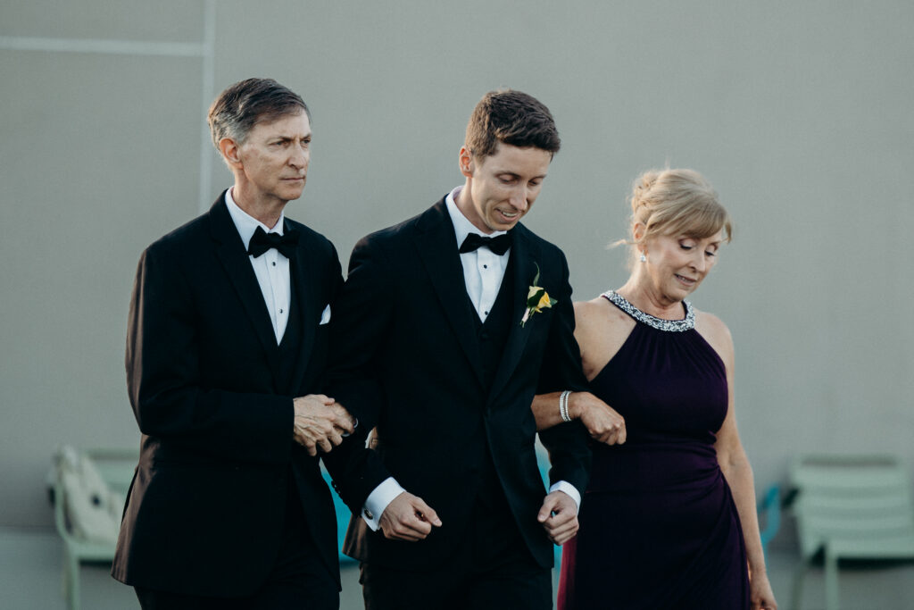 Groom walking down the aisle with his parents at The Asbury Hotel wedding ceremony