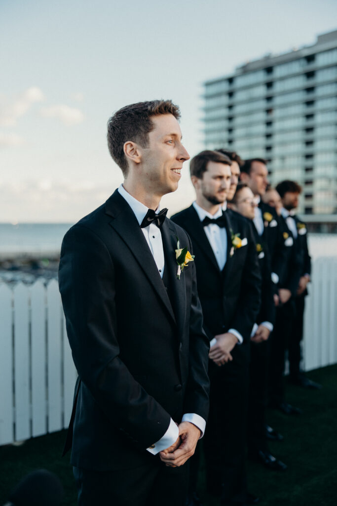 Groom watching the bride walk down the aisle during the wedding ceremony at The Asbury Hotel