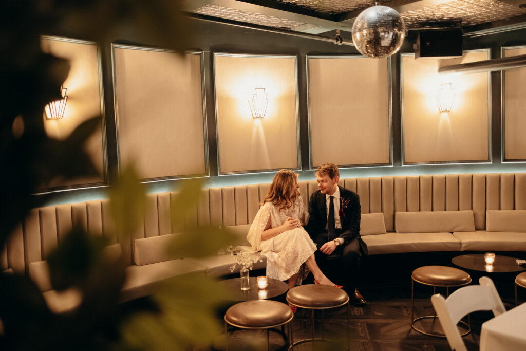 Bride and groom sitting together in lounge at Madeline’s Brooklyn