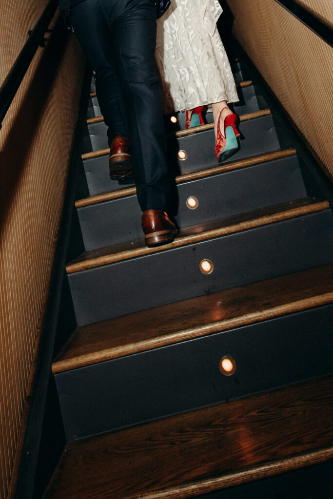 Couple walking up the stairs together during reception