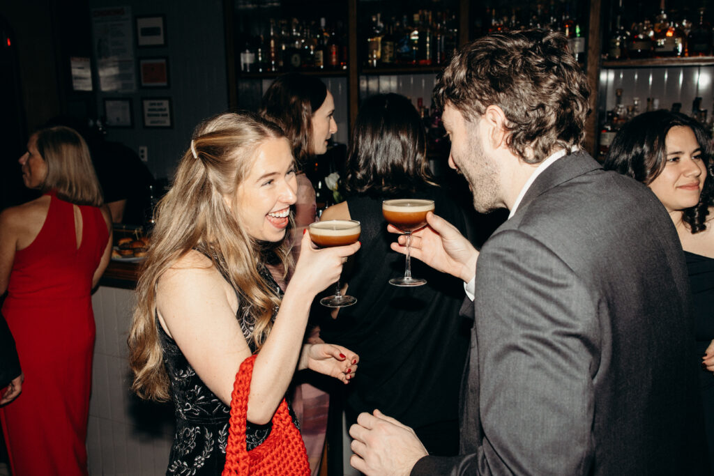 Guests toasting cocktails and enjoying the wedding party