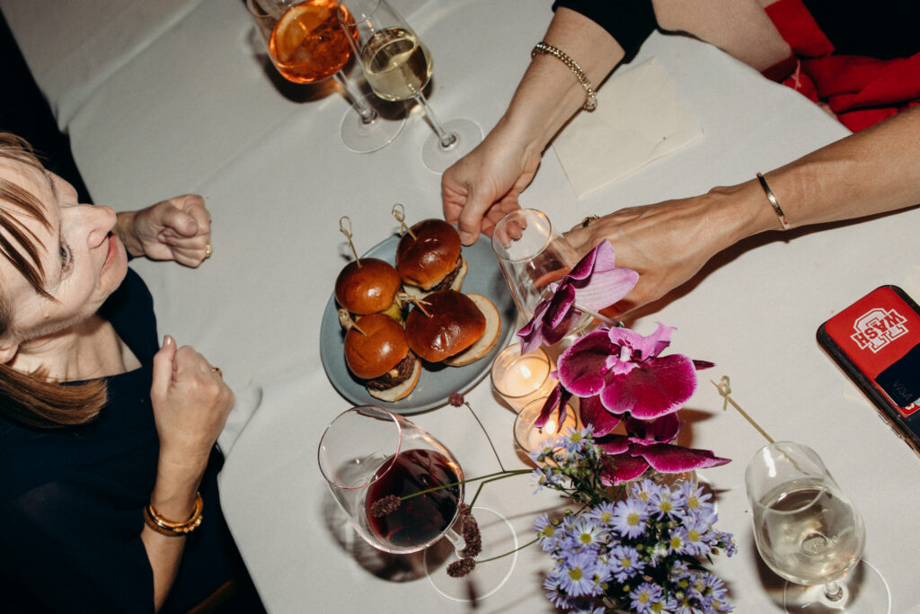 Wedding reception table details with sliders, wine, and florals