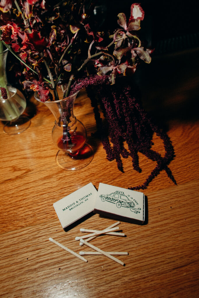 Wedding details featuring matchboxes and floral arrangement
