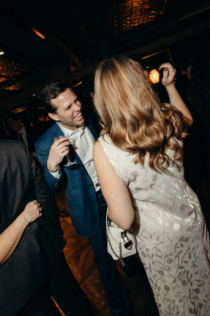 Guests dancing and laughing together on the wedding reception dance floor