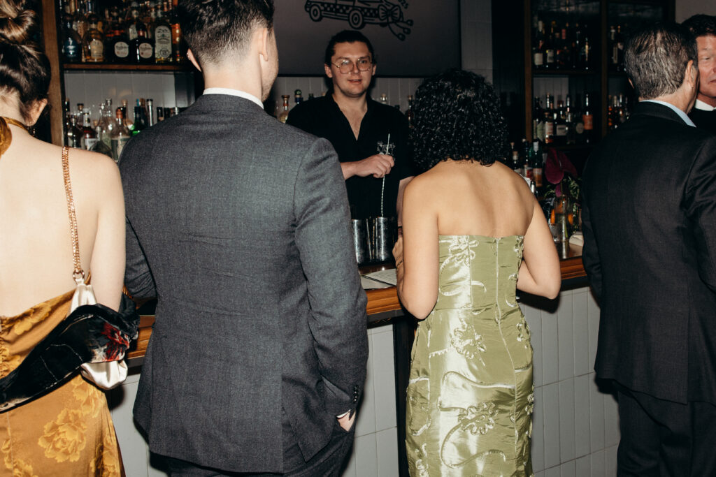 Bartender serving drinks to wedding guests at reception bar