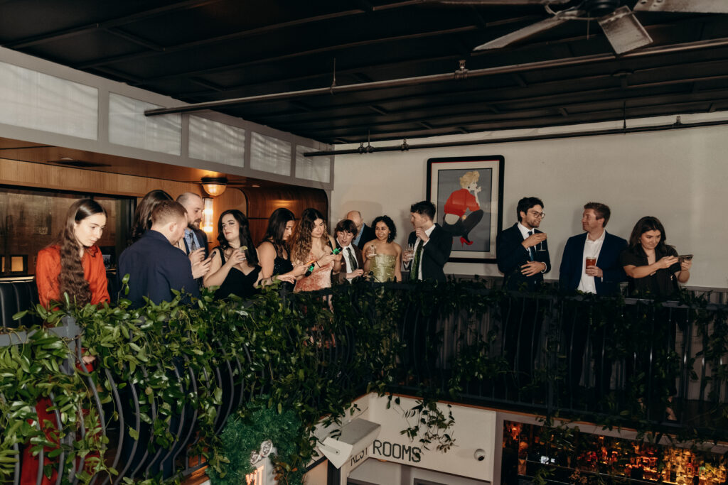 Guests gathered on balcony overlooking ceremony at Madeline’s Brooklyn wedding