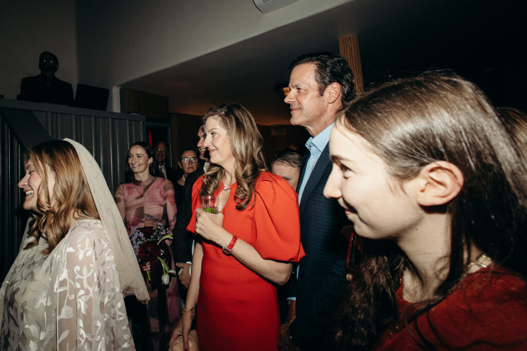 Wedding guests smiling and watching ceremony inside Madeline’s Brooklyn venue