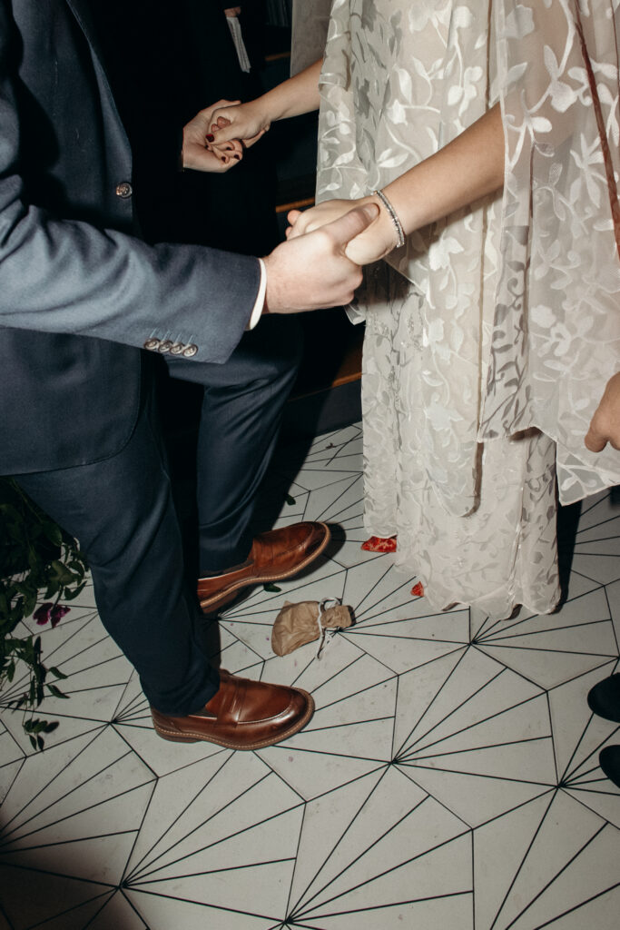 Close-up of bride and groom holding hands during wedding vows