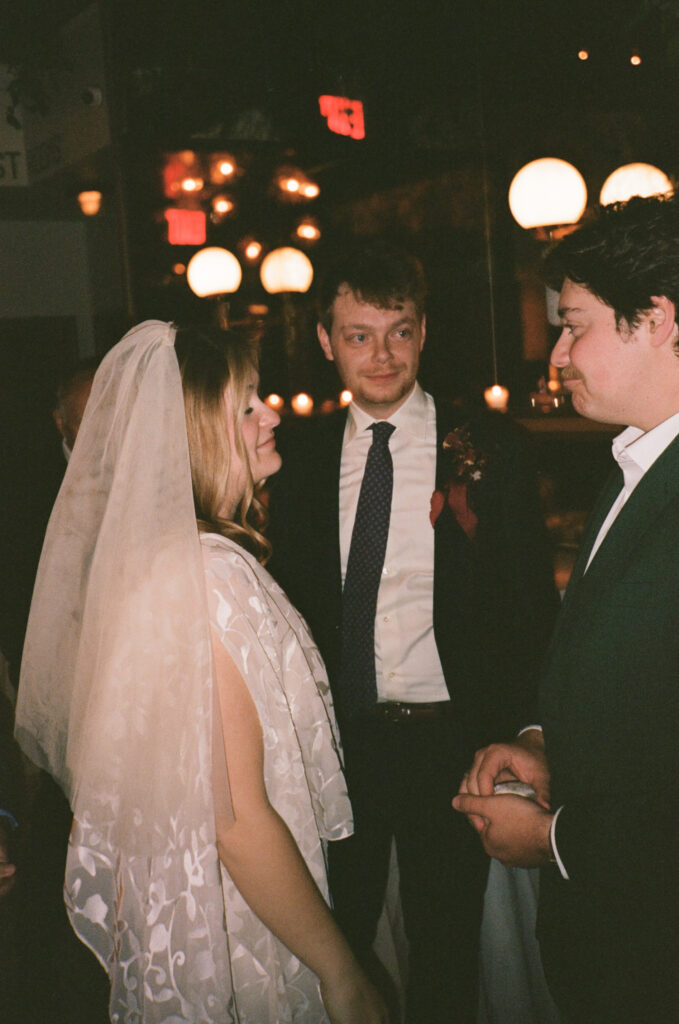 Wedding ceremony moment with bride and groom exchanging vows at Madeline’s Brooklyn under warm candlelight