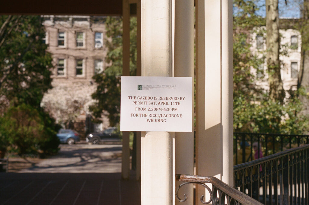 Wedding reservation sign posted at a park gazebo for the Ricci and Lacobone wedding ceremony