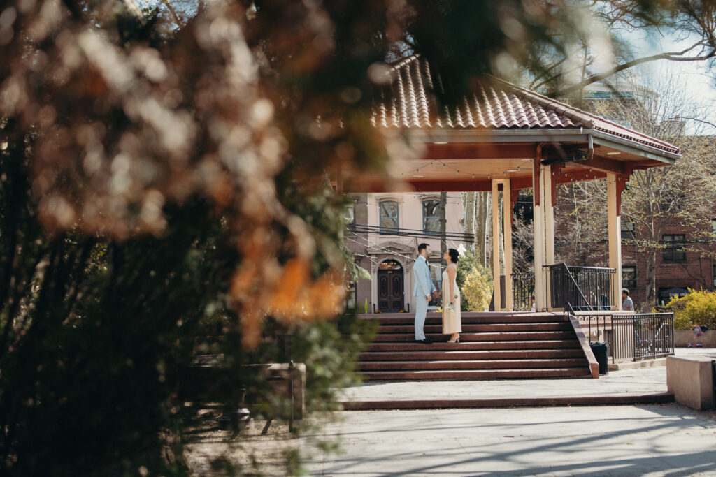 Sean and Giana’s intimate spring wedding ceremony at a gazebo surrounded by blooming trees in Jersey City