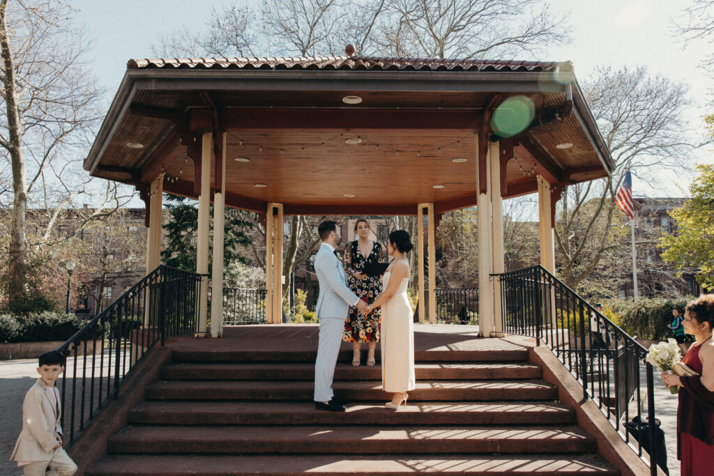 Bride and groom standing together at a gazebo during their intimate Jersey City wedding ceremony