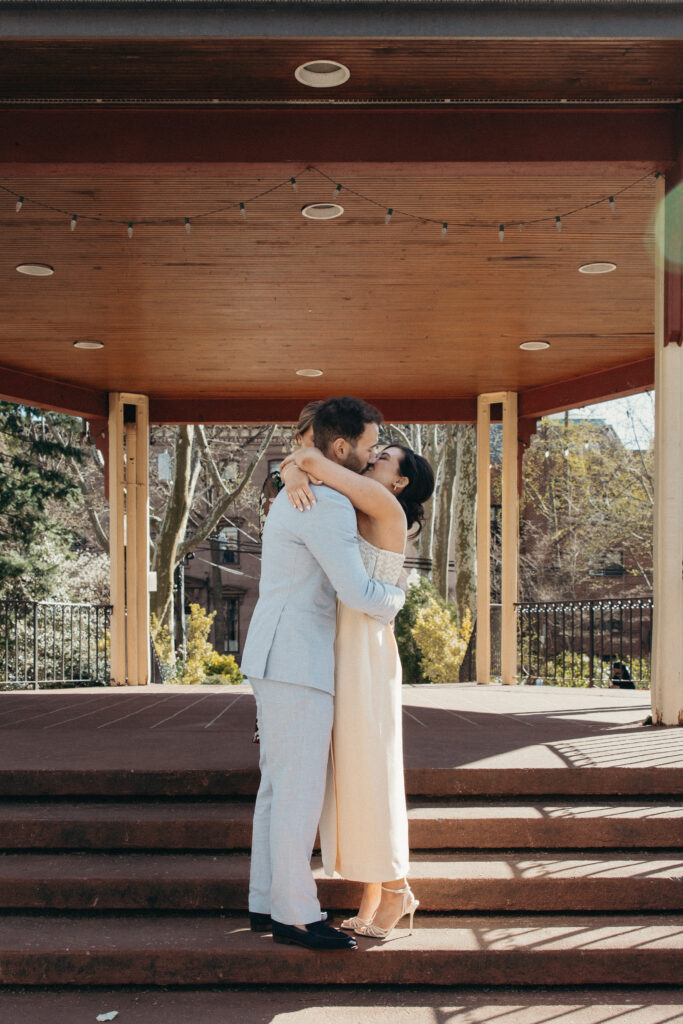 Bride and groom sharing their first kiss after exchanging vows at their spring wedding ceremony