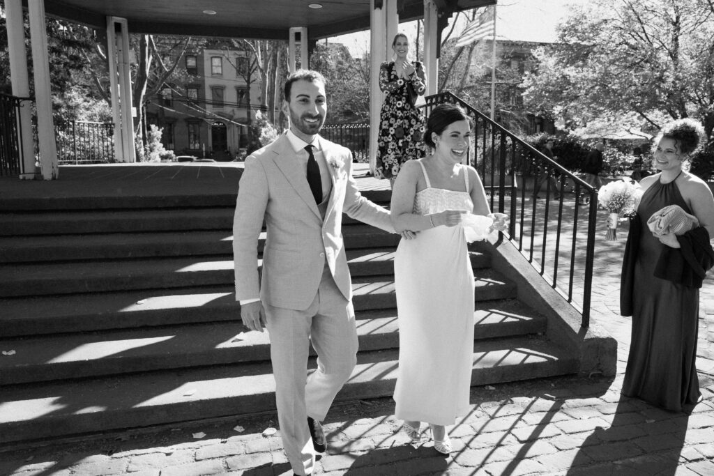 Bride and groom walking back down the aisle after their outdoor wedding ceremony in black and white