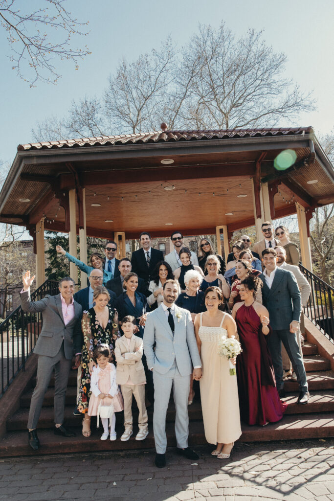 Wedding party portrait with bride and groom in a Jersey City park surrounded by spring blossoms