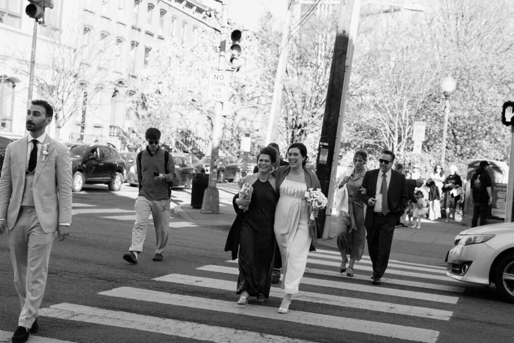 Bride and guests crossing a Jersey City street after the intimate outdoor wedding ceremony in black and white