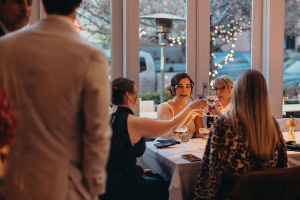 Bride raising a glass during an intimate wedding toast with family and friends